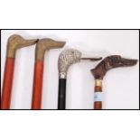 A group of vintage walking stick canes all having figural handles to include a silver plated duck