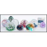 A collection of nine 20th century glass paperweights, the paperweights predominately by Caithness,