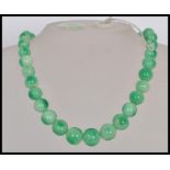 A vintage Chinese green jade prayer bead necklace having a graduating set of round beads and