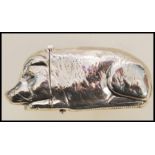 A stamped sterling silver vesta case in the form of a pig having a match striker to the base and