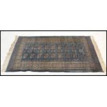 A late 20th century Indian machined carped floor rug having a deep teal blue ground having geometric