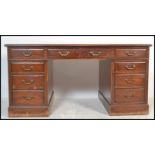 A 20th Century mahogany twin pedestal partners desk, having an arrangement of nine drawers with