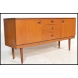 A retro 20th Century teak veneered sideboard, having a central bank of three drawers flanked by