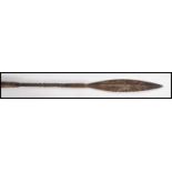 An early 20th century West African throwing spear having a wooden handle with metal twist binding.