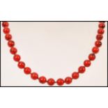 A vintage early 20th century red hardstone bead necklace having a gold claw clasp.