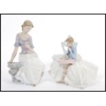 A pair of Lladro type Nao figurines of seated figures models 1355 and 1392. Printed marks to base.