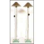 A pair of brass and glass contemporary standard lamps. Each raised on glass terraced bases with