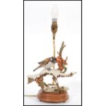 A vintage Capodimonte ceramic table lamp in the form of a bird raised on naturalistic scenery and