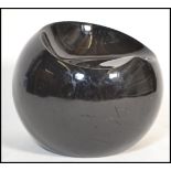 A contemporary 1970's style black gloss fibreglass ball chair having a shaped seat to top in the