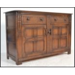 A 20th century Ercol ' Colonial ' beech and elm wood sideboard. The chamfered and flared edge top