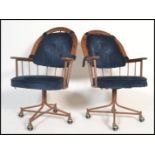 A pair of 20th Century American retro vintage office swivel desk chairs being of metal construction;