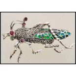 A stamped 925 silver plique a jour brooch in the form of a grass hopper set with rubies to the