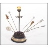 A collection of late 19th / early 20th Century hat pins, stored within a silver plated hat pin