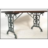 An early 20th century cast iron garden table having a painted scrolled cast iron base with wooden