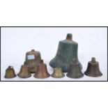 A collection of hanging bronze and brass bells dating from the 19th Century, varying in size with