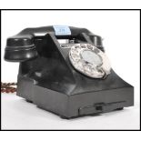 A vintage 1950's rotary bakelite telephone on a square base, having a pull out phone number tray,