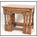 A 20th century oak nest of graduated tables by Jaycee, the flared tops raised on turned supports