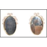 A pair of 20th century copper wall mirrors having scrolled frames with hammered design and central