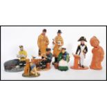 A collection of naive clay pottery figurines being hand painted and glazed in the manner of Royal