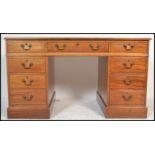 A 20th Century Georgian revival mahogany kneehole twin pedestal writing desk, with inset red leather