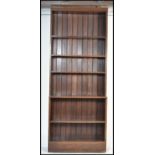 A large early 20th century solid oak library upright bookcase cabinet. Raised on plinth base with