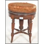 A late 19th century Victorian mahogany inlaid revolving piano stool. The upholstered swivel seat set