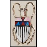 A silver brooch in the form of a beetle / bug having an enamelled back with a geometric pattern.