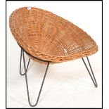 An original retro 20th century wicker tropics chair / armchair raised on a tripod hairpin leg