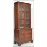 A 20th Century Regency revival mahogany bookcase over chest of drawers. The cabinet having  twin