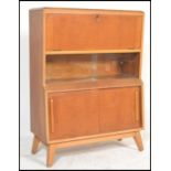 A vintage retro 20th century teak bureau raised on angular legs with sliding glass and wooden doors.