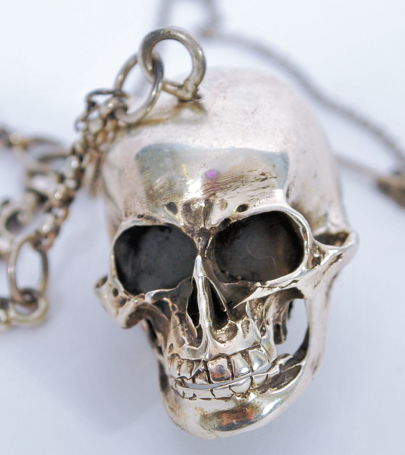 A gentleman's sterling silver albert watch chain having an articulated skull and and skeleton
