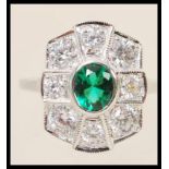 A stamped sterling silver ring in the Art deco style set with a central oval cut green stone and
