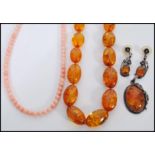 A selection of amber type jewellery to include a beaded necklace, a marked 925 silver pendant set