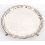 A 20th Century silver hallmarked tray / salver having a shaped rim raised on pad feet. Marked for