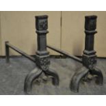 A pair of 19th century French cast iron fire irons having ebonised finish with ram head masks and