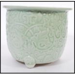 A 19th century Chinese Celadon glaze planter raised on scrolled feet with decoration of swags and