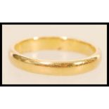 A 22ct gold wedding band ring being hallmarked to inner shank for Birmingham, Maker HS, Size Q.