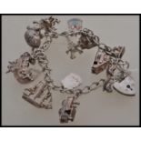 A silver hallmarked charm bracelet together with fifteen assorted charms to include a hinged
