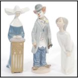 A group of three Lladro porcelain figures to include a Nun, girl and clown. Printed marks to base.
