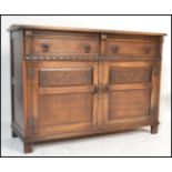 An oak Jaycee sideboard, rectangular oversailing top, two fluted short drawers over carved panel two
