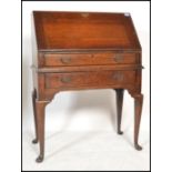 A 1920's Jacobean revival oak bureau desk being raised on cabriole legs with pad feet. Single