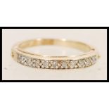 A 9ct gold ladies ring set with white accent stones to the band and a hidden hinged section to the