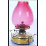 A 19th Century Victorian oil lamp having a large round brass base with handles to either side raised