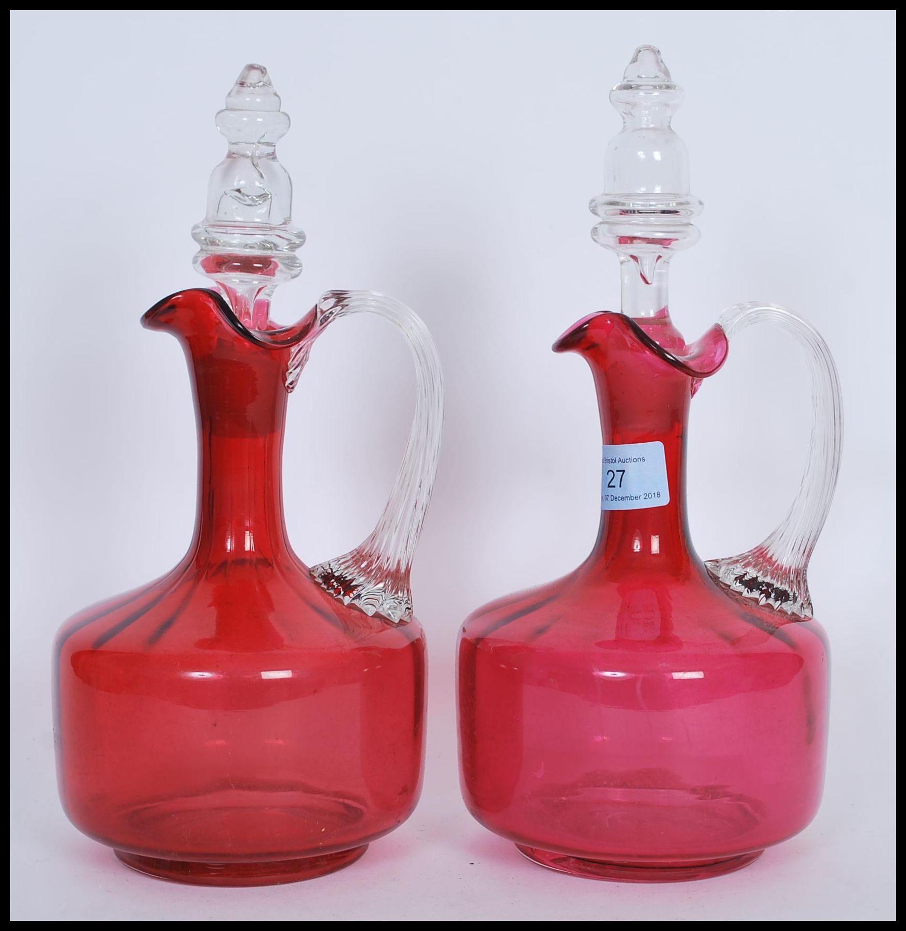 A pair of 19th Century Victorian cranberry glass decanters, both fitted with original cut glass