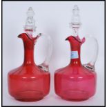 A pair of 19th Century Victorian cranberry glass decanters, both fitted with original cut glass