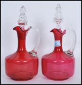 A pair of 19th Century Victorian cranberry glass decanters, both fitted with original cut glass