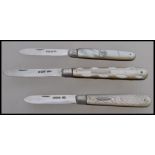 A group of three silver hallmarked and mother of pearl handled fruit pen knives. One hallmarked