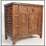 A good early 20th century Chinese sideboard cabinet having stunning carved, lattice decoration to