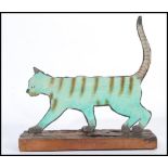 A vintage 20th century folk art painting on metal sculpture of a cat being raised on a live edge