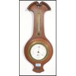 A 20th Century wooden case wall barometer / thermometer by Negretti & Zambra having a scrolled